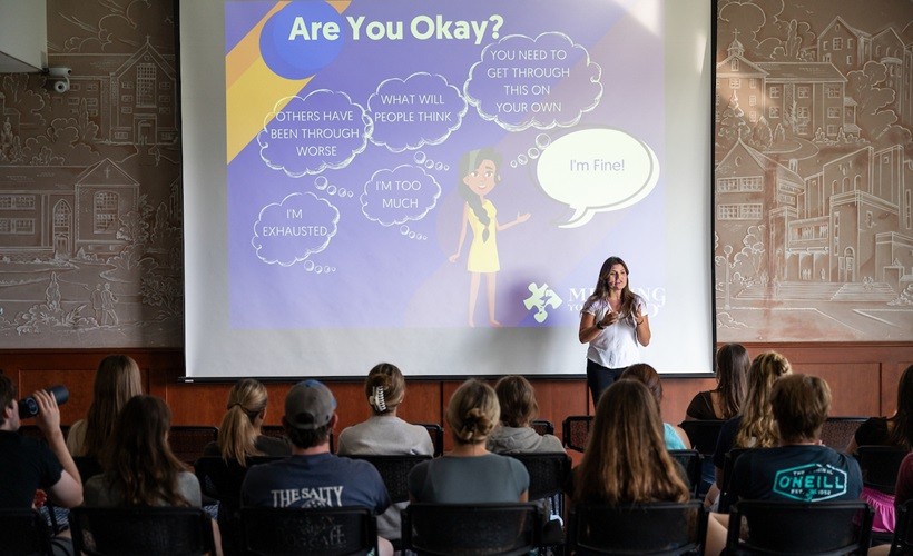 Students listen to a presentation on mental health