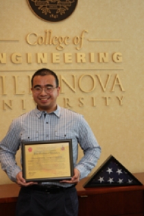Thong Nguyen EE '06 presents an American flag and a certificate of authenticity signed by his commanding officer to the College of Engineering.