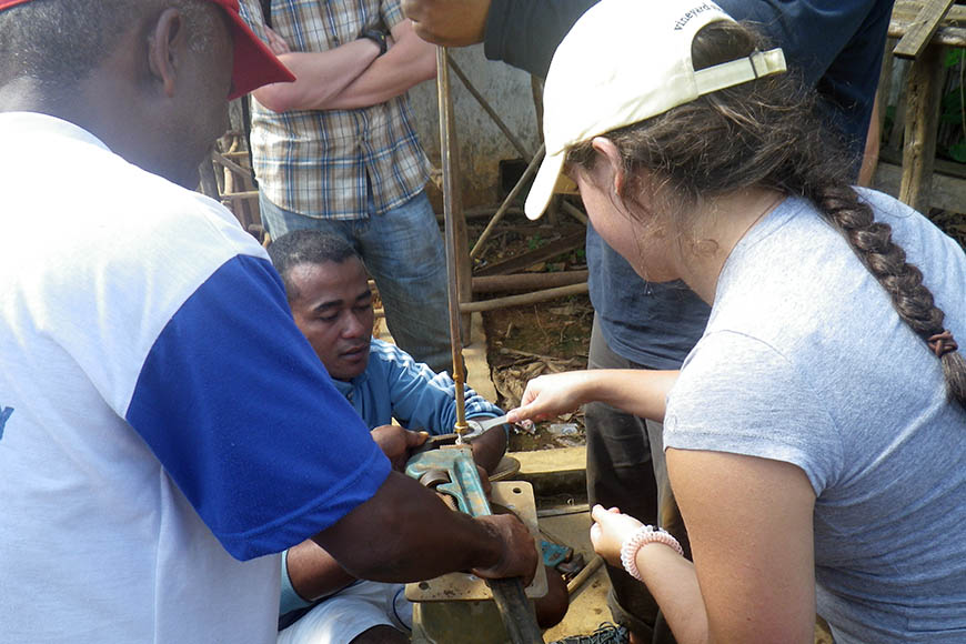 Stephanie Krakower ’18 CE works on a broken hand pump with CRS engineer Jean Amie.