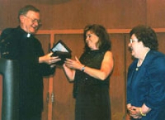 As Dean Fitzpatrick looks on, University President Rev. Edmund J. Dobbin, OSA presents Ms. Emily Riley of the Connelly Foundation with a token of appreciation after her announcement of its $4 million endowment of College of Nursing initiatives in celebration of the College’s 50th anniversary. April 26, 2004.