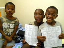 Young boys at St. Theresa's Home for Children hold their health screening record created by faculty Prof