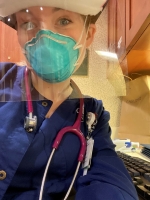 Female nurse in the hospital wearing a mask and shield.
