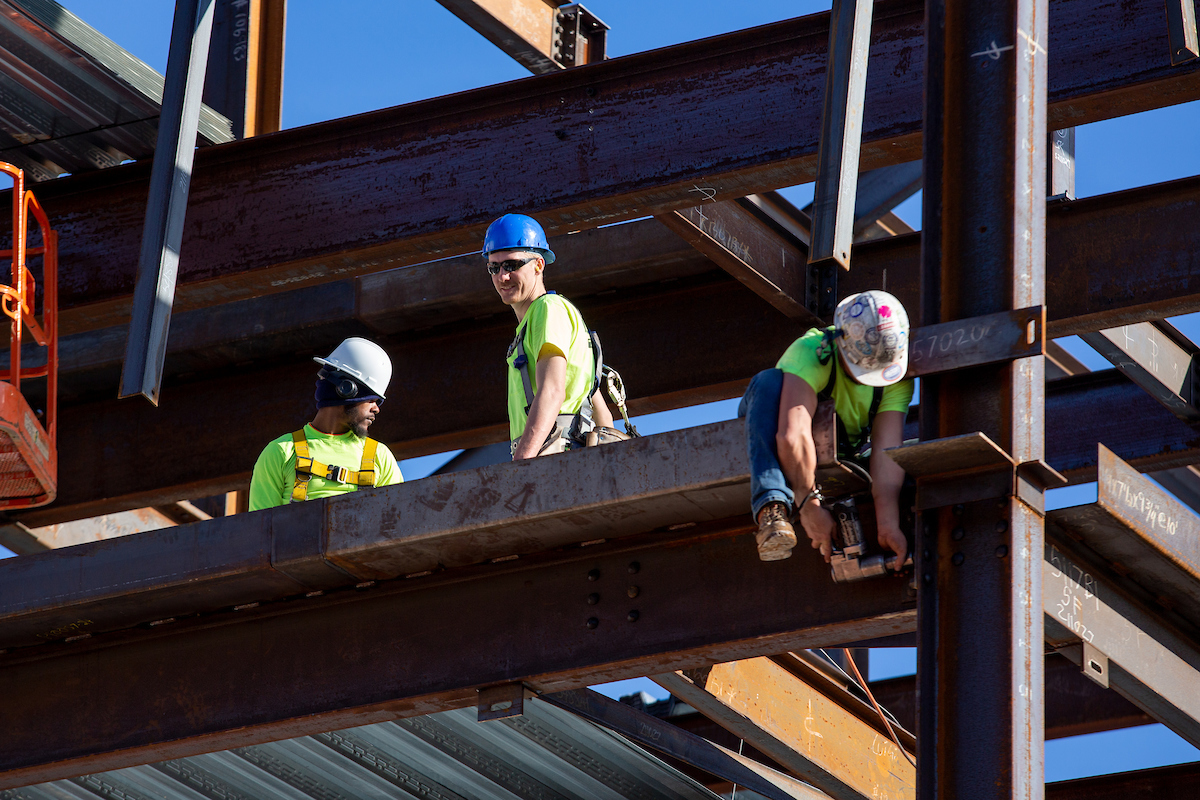 men on construction site installing steel beams