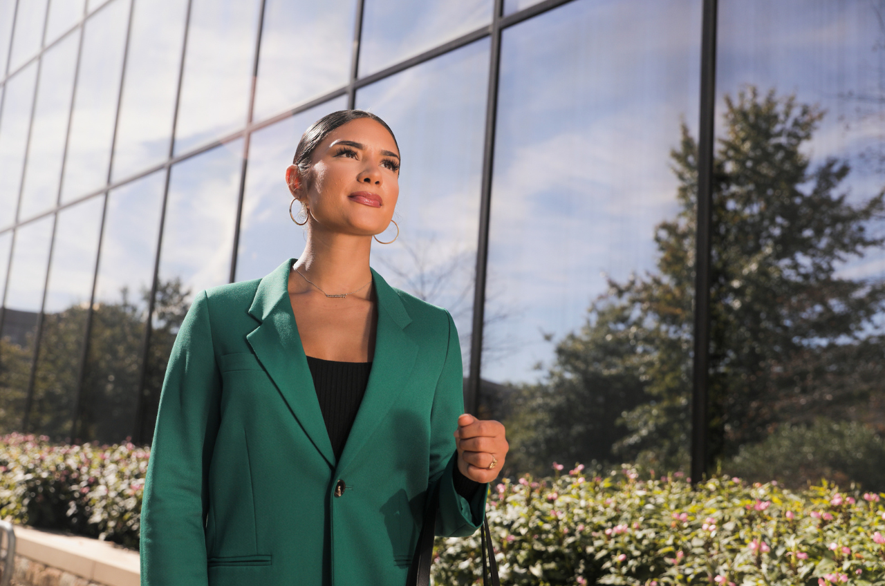 woman standing and looking up outside of an office building