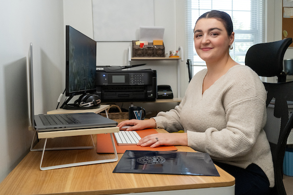 woman in office with laptop looking at the camera