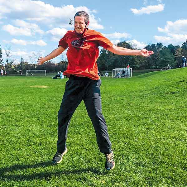 male Special Olympic athlete jumping outside