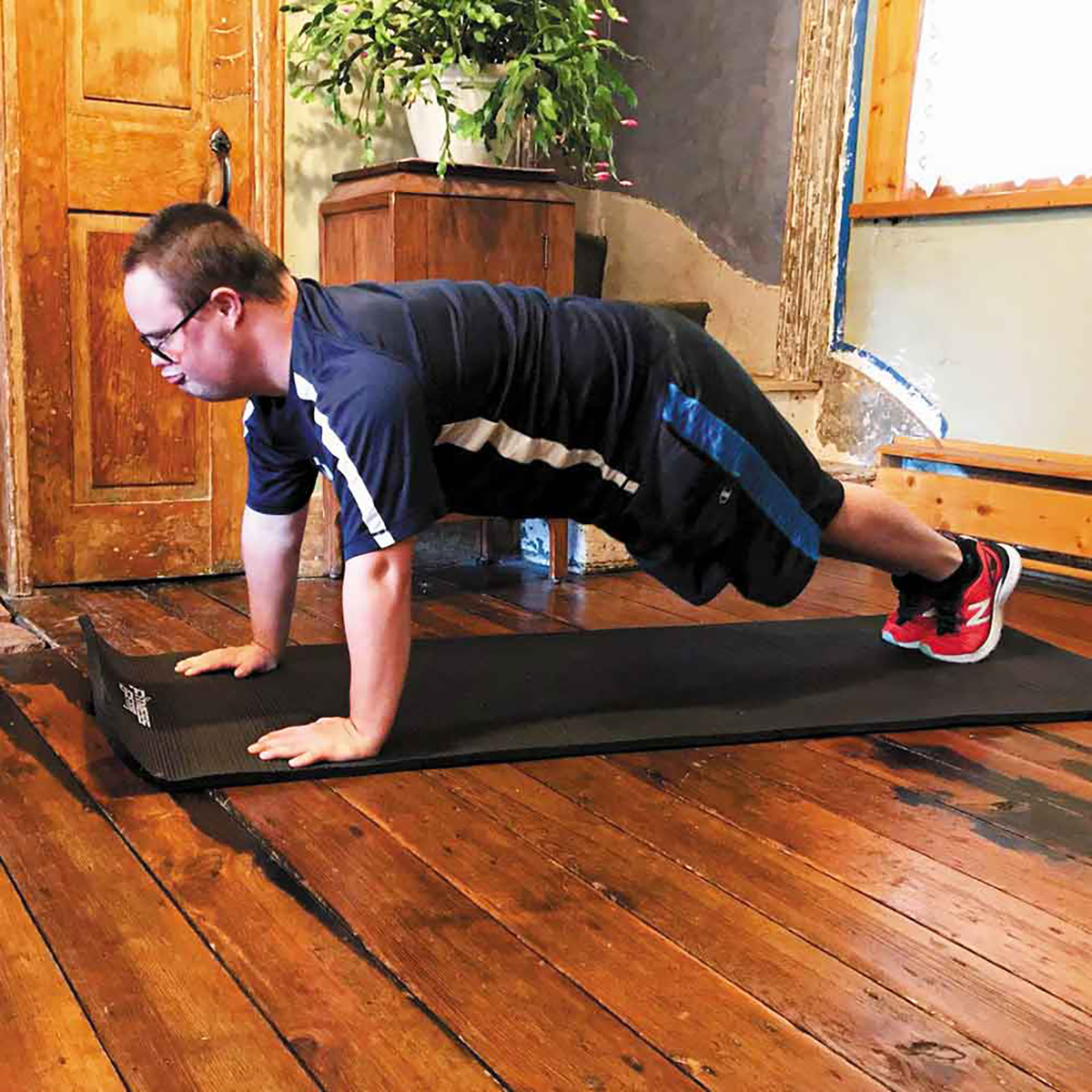 Special Olympic athlete inside doing push-ups