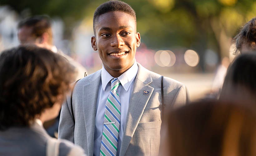 Student in suit looking away from camera