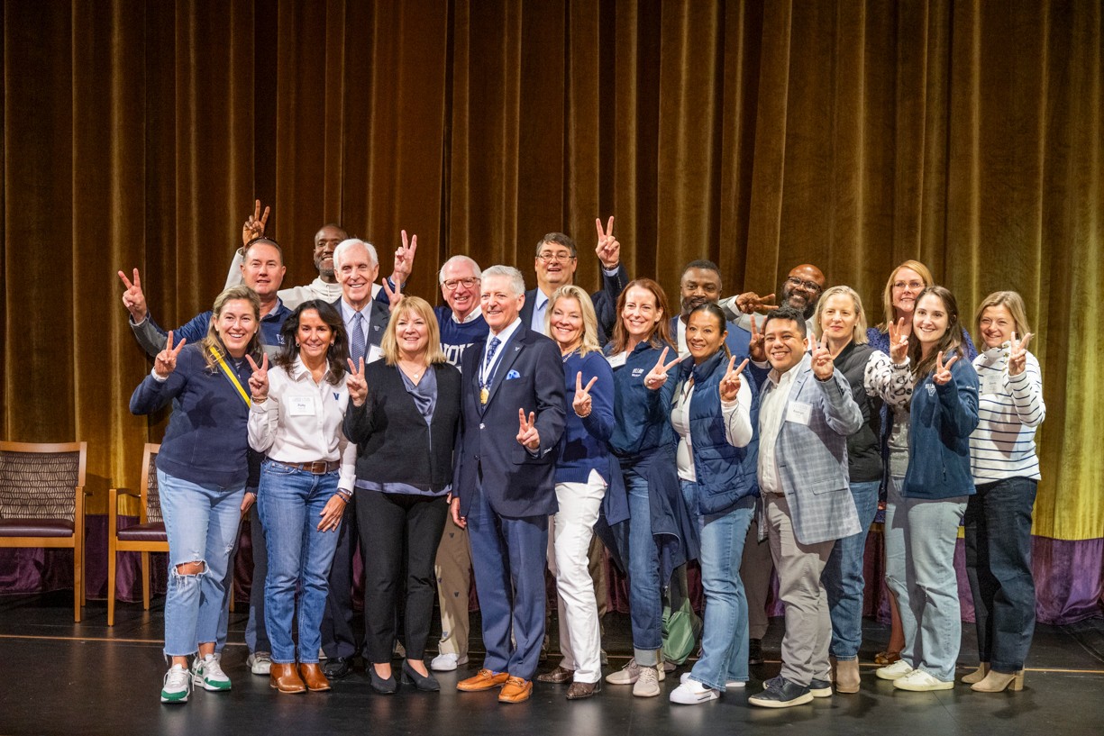 George Kolb '84, AVP of Alumni Relations, and the Rev. Peter M. Donohue, OSA, posing on stage with five alumni award winners
