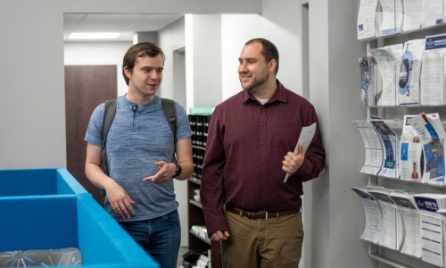 CSO692_20250415_1595 _Navigate Student speaking to a staff member as they both are walking through the Career Center.