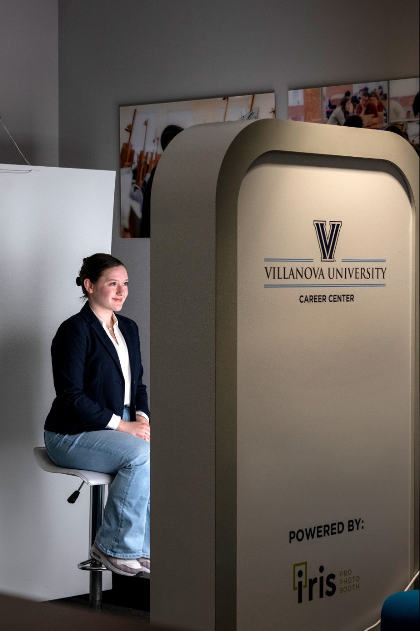 Student taking their photo in the headshot photobooth.