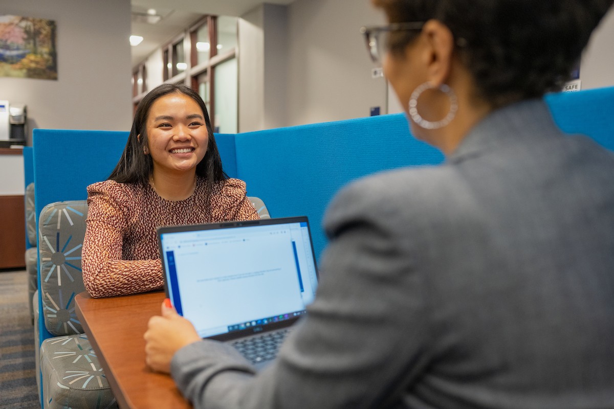 Student and career center employee sitting at a table in the career center talking.
