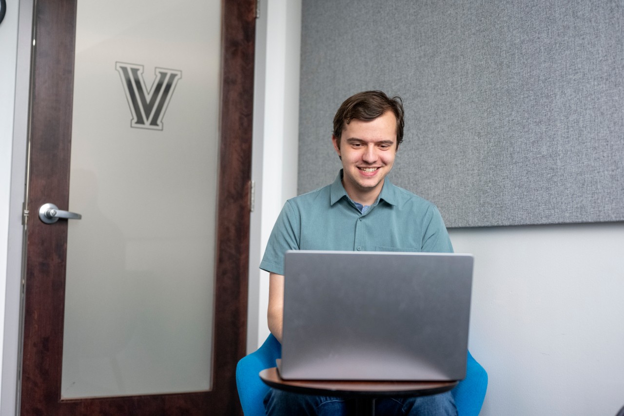 Student looking at laptop in an interview room in the Career Center.