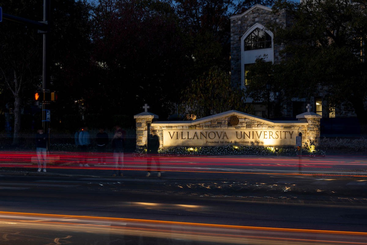 A Villanova sign at an intersection with car lights passing by