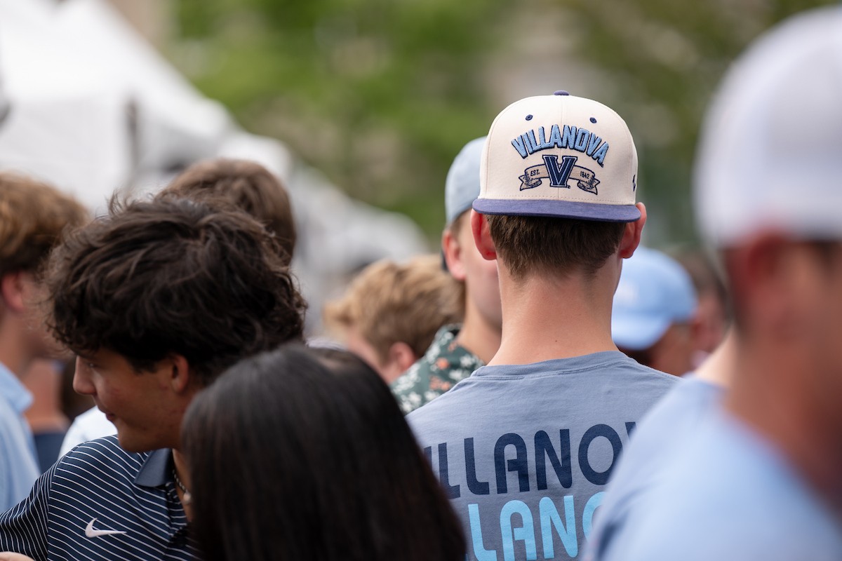 A student facing away from the camera wearing a Villanova hat