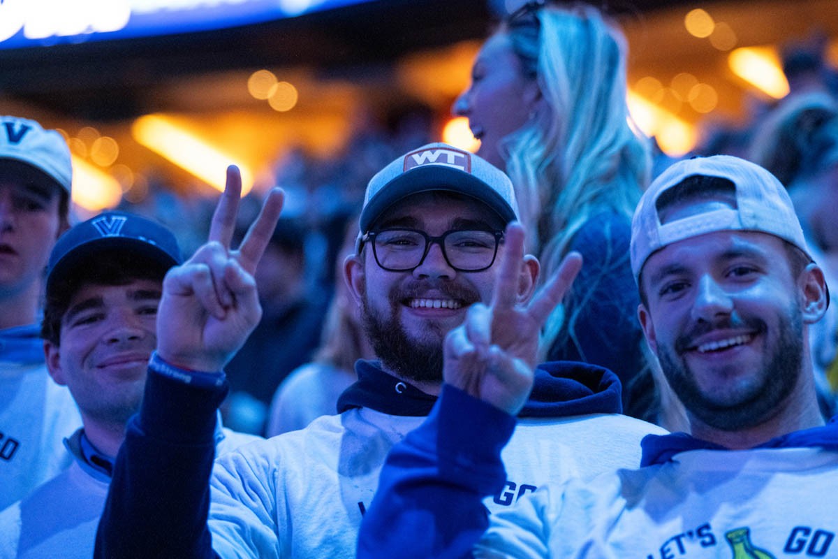 CSP553_20250221_0441 Male students throwing up a Villanova "V"