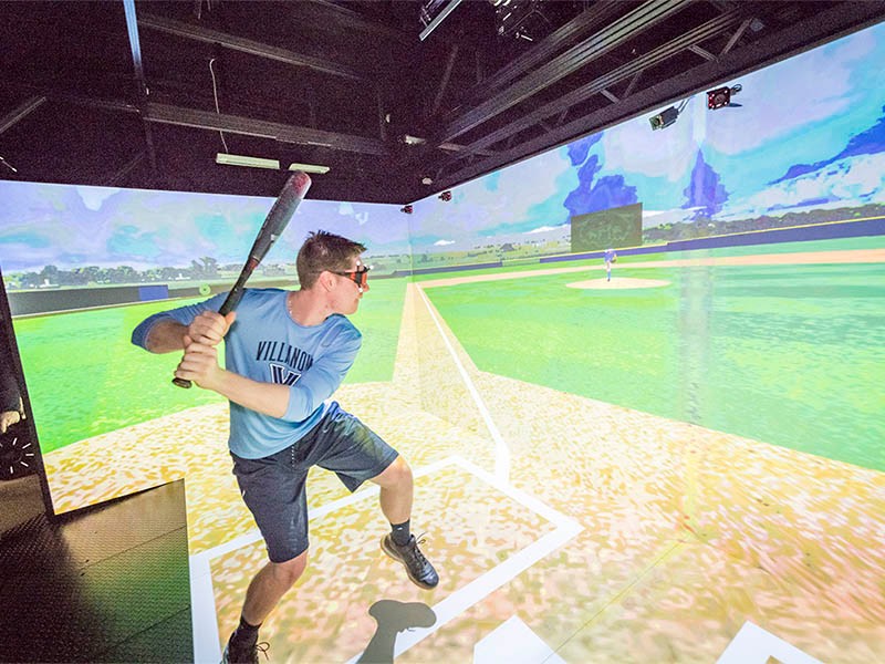 A student in a baseball simulator A student in a baseball simulator