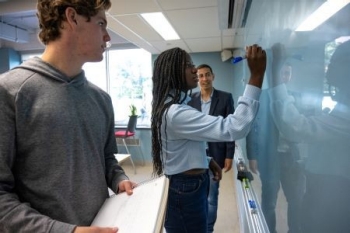 Students at the white board in the IIE