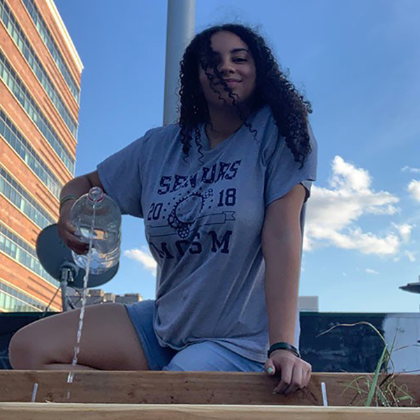 Research and Resilience Hannah Darensbourg ’22 watering research garden on the rooftop of her apartment
