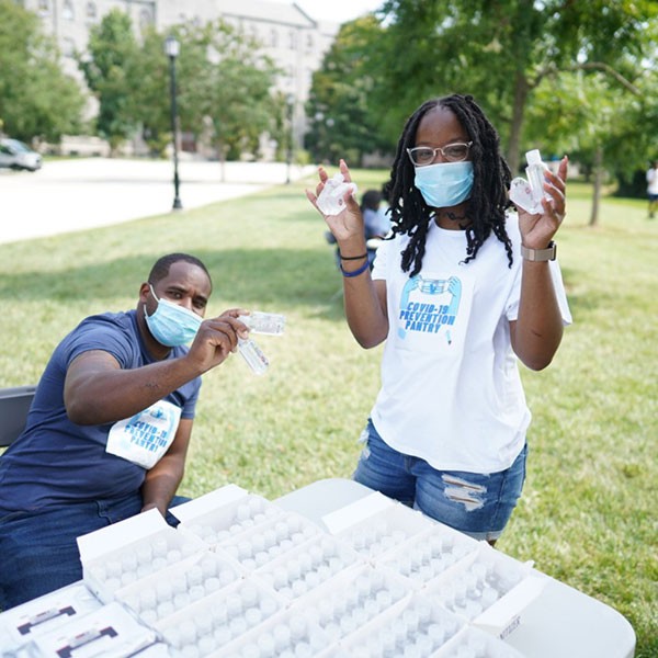 Jasmine Mays and a colleague outside wearing masks