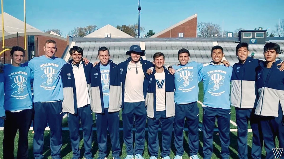 Villanova volunteers stand togther in a line across the field