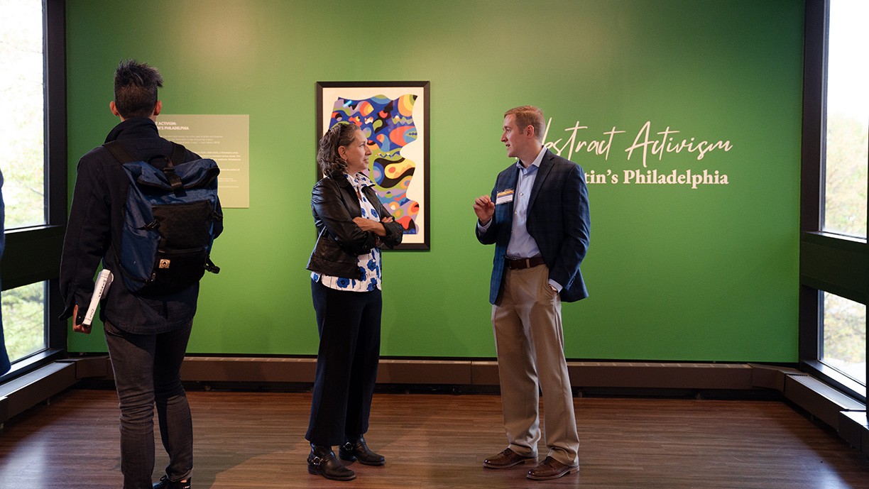 Patrons look at Sam Maitin art exhibit.