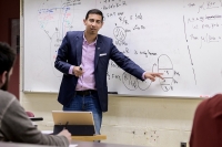 Mathematics professor in front of whiteboard with equation Mathematics professor in front of whiteboard with equation