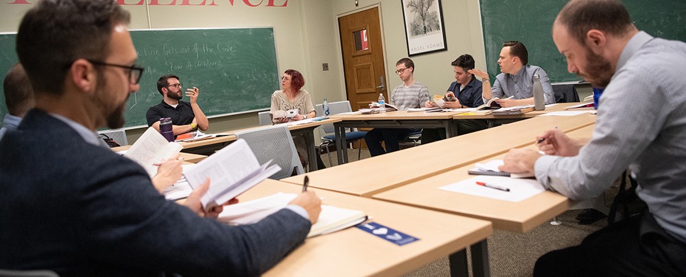 graduate students sitting around tables in a classroom