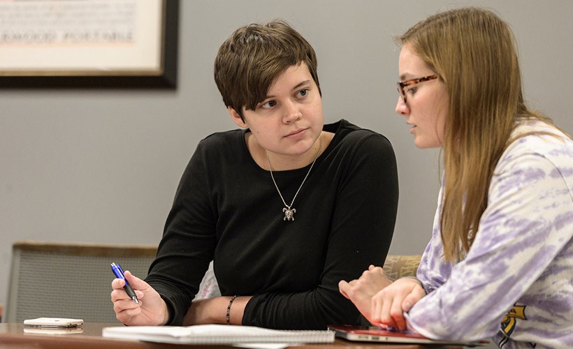 students work together at the writing center. Two students work together at the writing center.