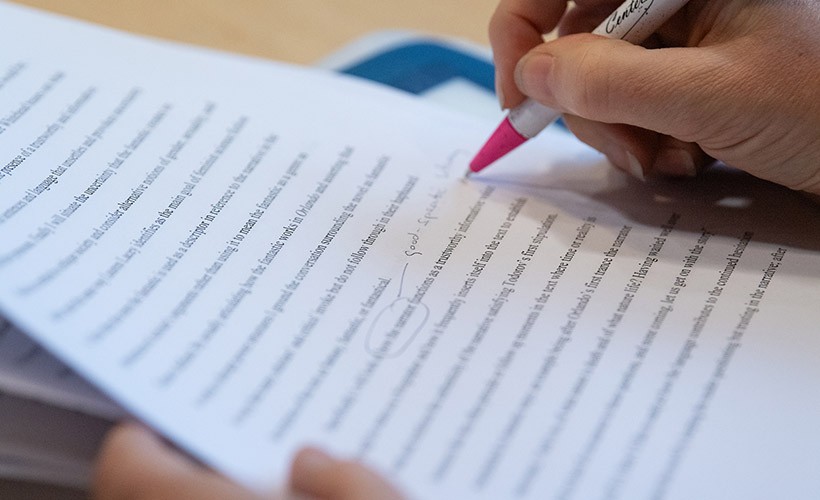 A close up of a student reviewing a paper.