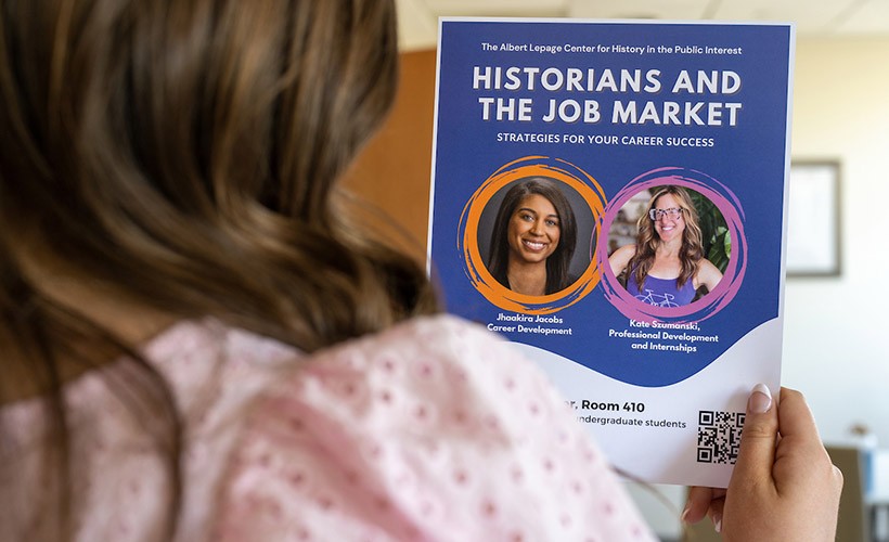 A student reads a poster about a History career event.