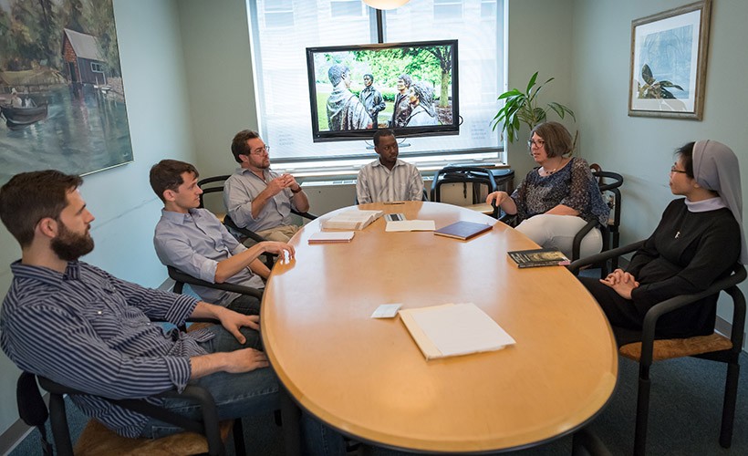Graduate students sit in a seminar discussion.