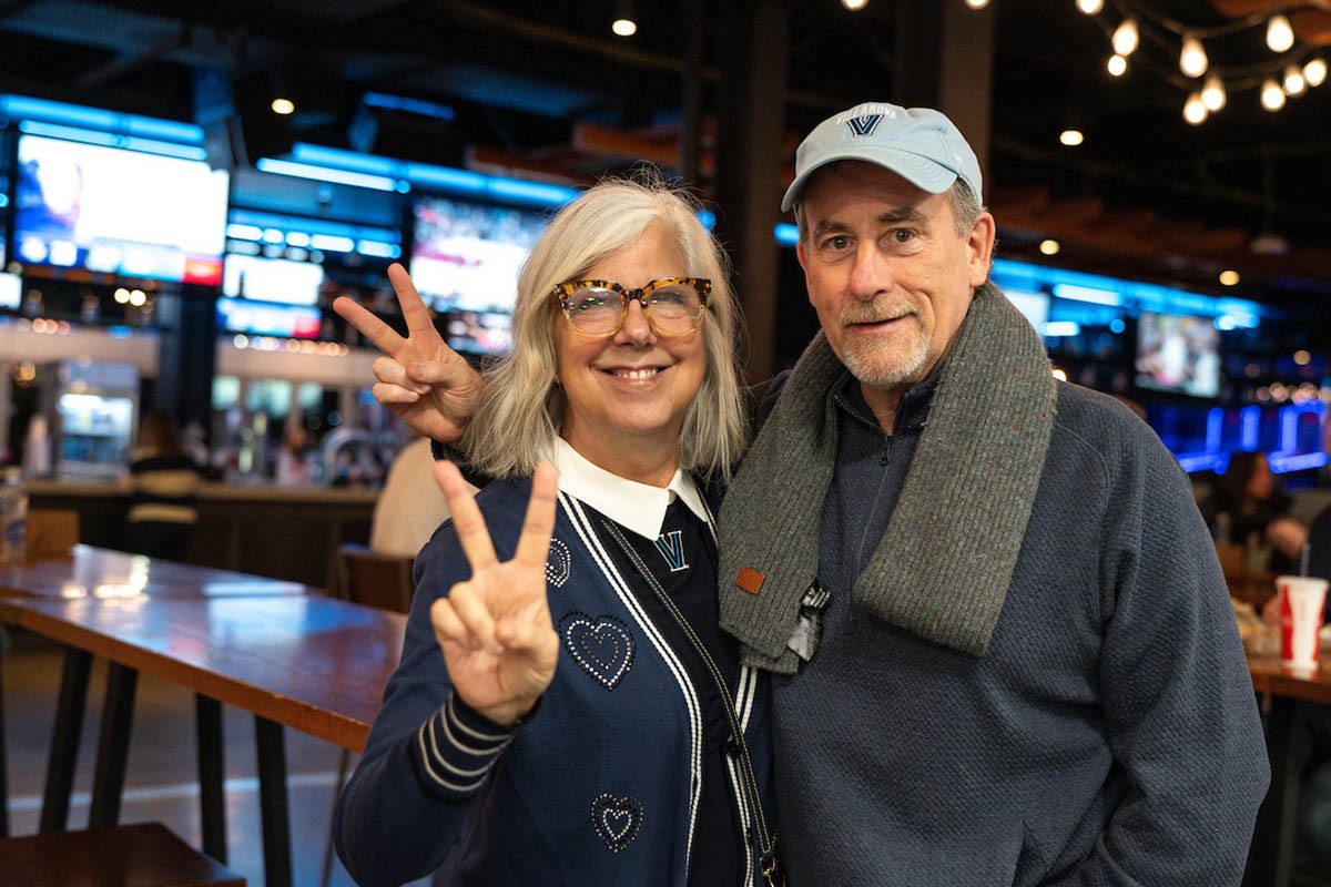 A couple throwing up the Villanova peace sign in Villanova gear