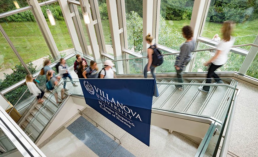 Students on the staircase in the main atrium of Driscoll Hall, home of the College of Nursing.