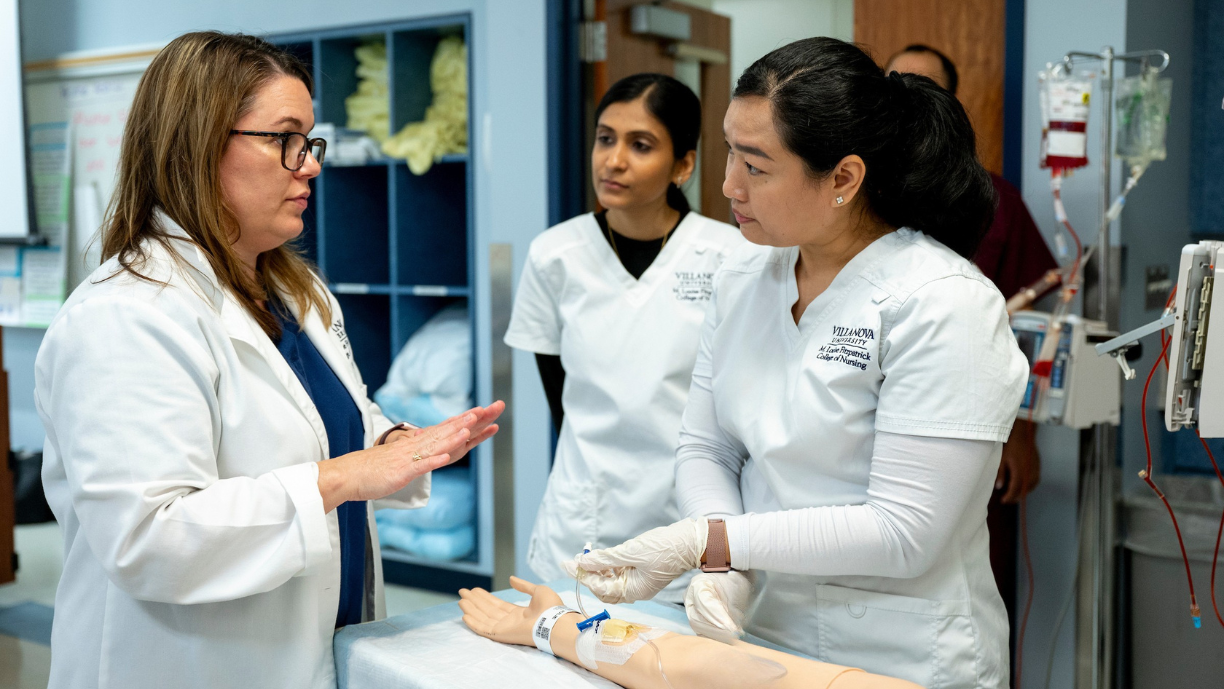 Nursing faculty teaching students how to work an IV