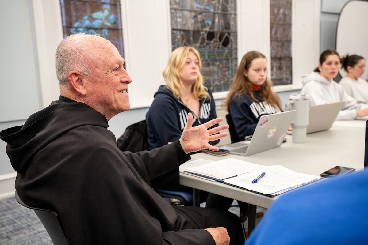 A priest talking with students
