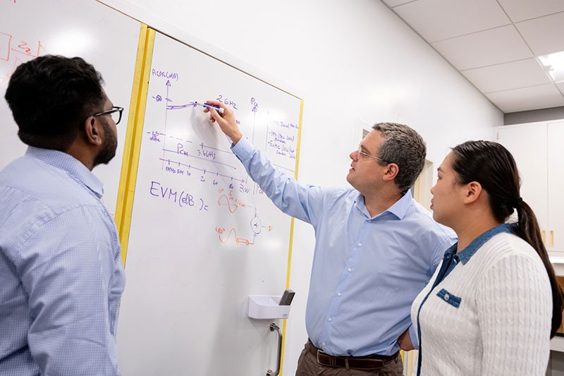 male-professor-students-whiteboard Male professor drawing on whiteboard with students