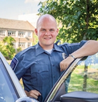 A Villanova Public Safety officer stands next to a car