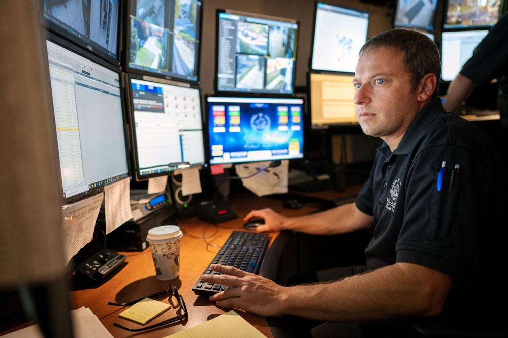 Public safety officer at desk with computer monitors