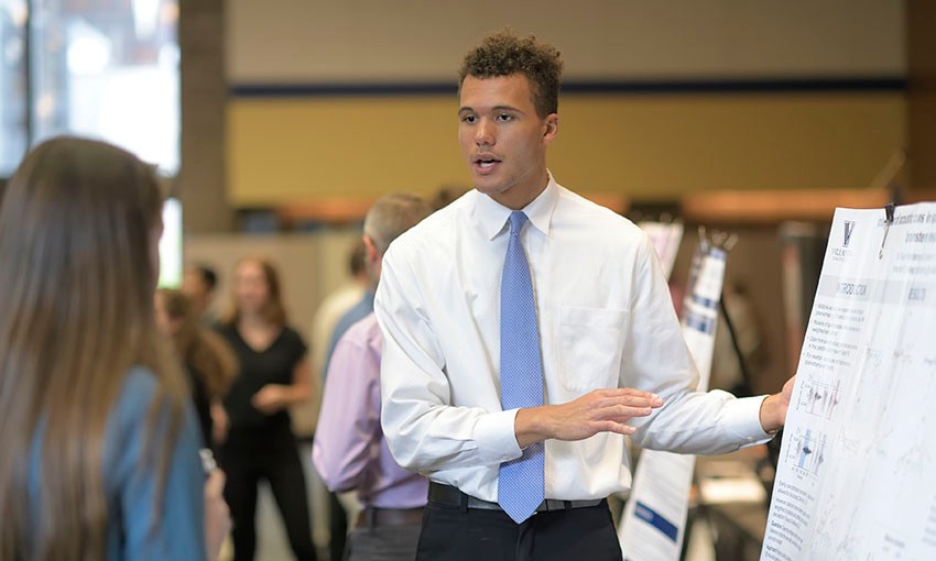 Student presenting research at poster session