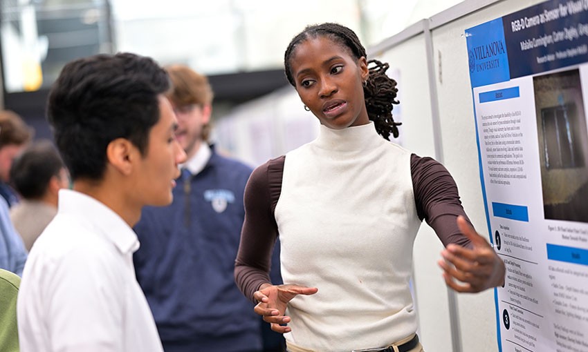 Student presenting research at poster session