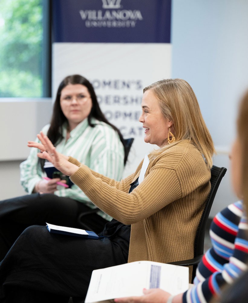 Women seated in a classroom having a discussion