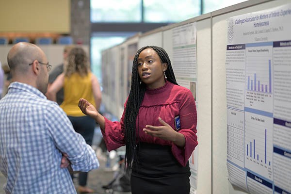 student-presenting-research-symposium Student presenting research at poster session