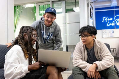 SLLC-Startup students sharing work on a laptop in a makerspace lab