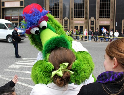 Phillie Phanatic mascot hugging a fan at a Philadelphia parade