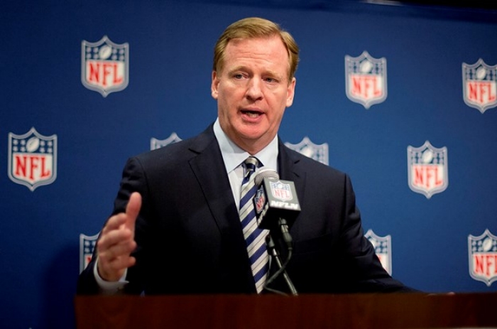 NFL Meetings Football NFL Commissioner stands at podium microphone with NFL logo backdrop