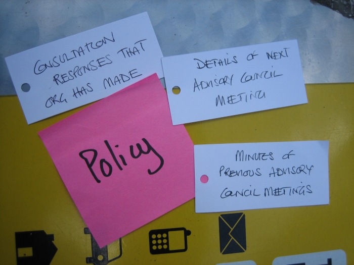 white note cards laid on top of a pink sheet of paper that reads policy