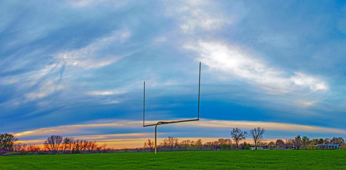 Rural sports field with football goalpost in the twilight