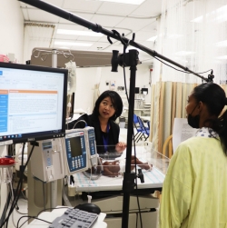 Dr. Sunny Hallowell in simulation lab with actress and neonatal ICU equipment and infant manikin