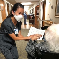 Female FCN nursing student works with an ederly female patient.